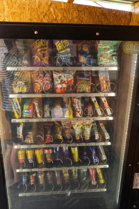 Ein Verkaufsautomat mit verschiedenen Snacks und Getränken in mehreren Reihen.